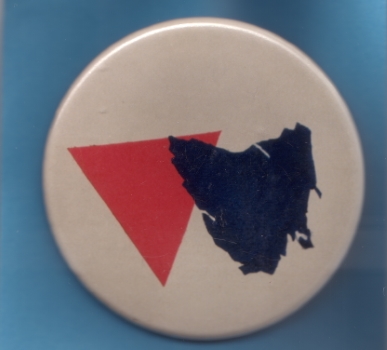 [Badge depicting a pink triangle and map of Tasmania] – Tasmanian Gay and Lesbian Rights Group (TGLRG), c.1988, 2-12-1